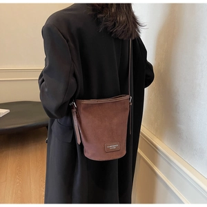 Detailansicht der dunkelbraunen Wildleder-Beuteltasche mit Leder-Logo-Patch