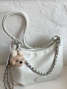 White hobo shoulder bag with leather texture, silver chain strap and plush puppy charm