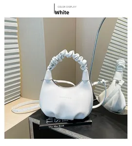 Detail of white pleated handle and lychee grain leather texture on the handbag