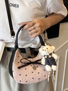 Pink pleated crescent bag with black bow details and cute bear charm for women