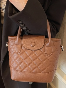 French style brown quilted bucket bag with top handles and pebbled leather texture
