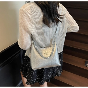 Détail du sac à bandoulière en cuir froissé argenté avec boucle étoile et chaîne