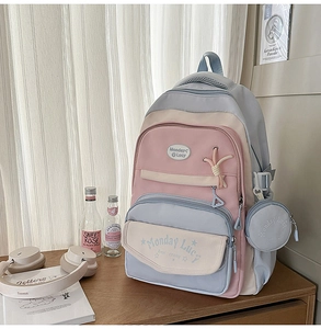 Detail showing macaron color block design and multiple zipper pockets on school backpack