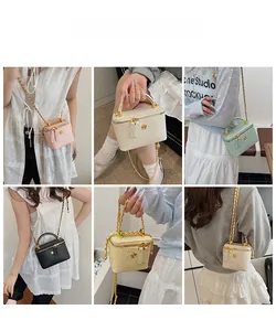 Mini box cross-body bags in ostrich texture with gold chain straps and floral emblems