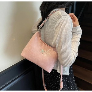 Détail d'un sac à main rose brillant avec étoile en strass et chaîne en métal argenté