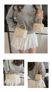 Detail showing white textured box bag in two sizes with gold chain and flower hardware