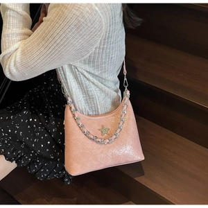 Détail du sac à bandoulière rose en cuir verni plissé avec chaîne argentée et étoile