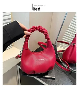 Detail of red ruched handle handbag with litchi texture leather and Fashion text