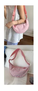 Detail showing the pink gingham pattern texture and striped adjustable strap of the bag