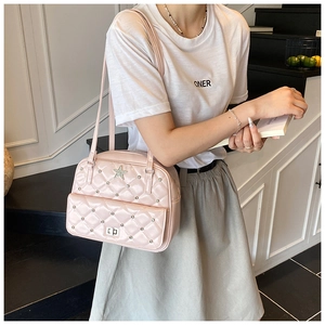 Close-up of pink quilted shoulder bag featuring star studs and a silver turn-lock closure