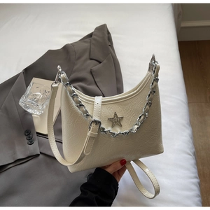 Détail du sac crème avec texture plissée et décoration étoile en strass brillant