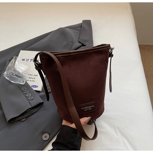 Nahaufnahme dunkelbraune Beuteltasche mit Lederprägung, mattem Finish und edlem Schultergurt