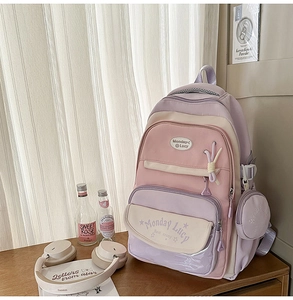 Detail of macaron color block school backpack with multi-pocket design and small round pouch
