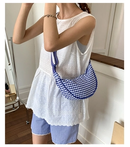 Blue gingham crescent bag shoulder strap detail on a casual minimalist crossbody bag