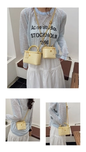 Detail of beige ostrich embossed box bag featuring gold chain and floral metal clasp