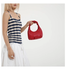 Close-up of red ruched leather handbag with Fashion & Bags logo and cloud-style handle