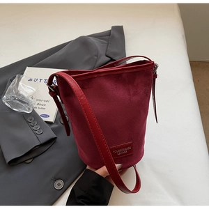 Detailansicht der burgunderroten Eimer-Tasche mit mattem Wildleder und Lederstiching