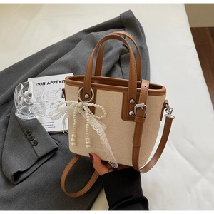 Details einer Canvas-Leder-Beuteltasche mit Perlen-Schleife und Spitzenanhänger