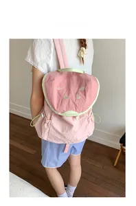 Detail of cute watermelon backpack featuring pink fabric and green embroidery accents