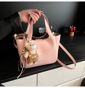 Pink faux leather bucket bag detail with MUHETI SHI SHANG embossing and cute bear charm