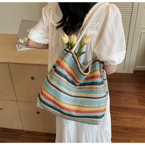 Détail d'un sac cabas tissé à rayures colorées avec des anses tressées blanches de qualité