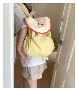 Detail of cute yellow apple-themed backpack with embroidery and drawstring closure