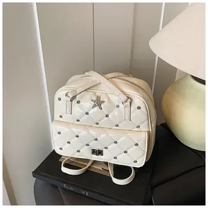 Detail of quilted beige leather bag with silver rivets and star crystal buckle