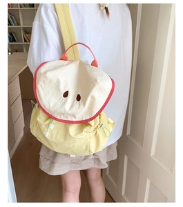 Detail showing the cartoon fruit backpack side drawstring pocket and bright nylon fabric
