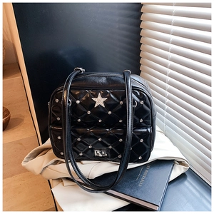 Detail of black quilted shoulder bag featuring silver studs and rhinestone star decoration