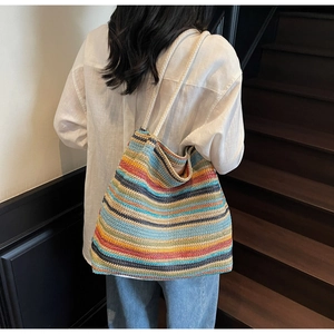 Gros plan sur un sac cabas tissé coloré montrant des rayures en coton et une anse en corde
