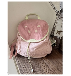 Detailed macro view of the watermelon design stitching and fabric on pink backpack