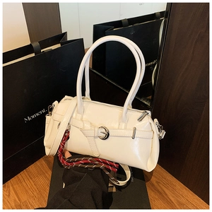 Détail du sac à main blanc en cuir brillant avec boucle en métal et lanière tressée