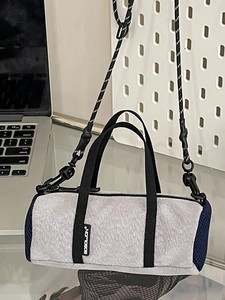 Sac cylindrique minimaliste en nylon gris avec bandoulière tressée et empiècements en mesh