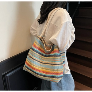Détail d'un sac cabas tissé à rayures colorées avec des anses en corde de coton blanc