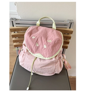 Detail of cute watermelon-themed pink and green nylon backpack with embroidery and drawstring