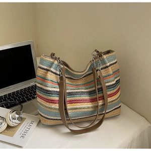 Detail of colorful woven tote bag featuring vibrant wave stripes and leather chain straps