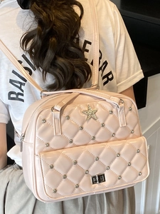 Pink quilted backpack with rhinestones and star emblem shown on model for women