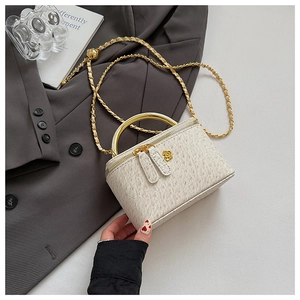 Close-up of cream ostrich-patterned leather handbag with gold rose hardware and chain