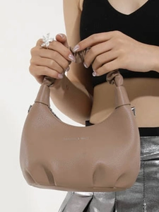 Minimalist wrinkled shoulder bag in earth-toned lychee grain leather with elastic handle