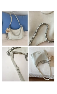 Detail view of white crescent bag showing silver chain strap and cute bear charm accessory
