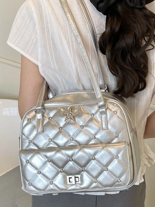 Silver quilted Y2K shoulder bag with rhinestone stars and dual straps on model back