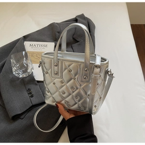 Detailed view of silver quilted bucket bag with metallic studs and stylish strap