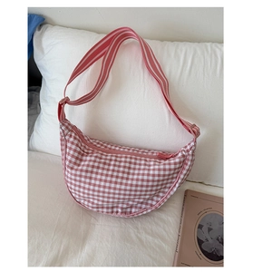 Close-up of pink and white checkered dumpling bag with adjustable striped shoulder strap