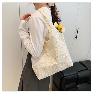 Detailed texture of lace flower embroidery on a cream canvas tote bag with large capacity
