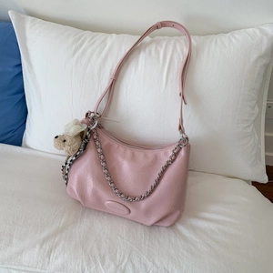 Detail of pink leather tote bag featuring a silver chain strap and a cute bear charm