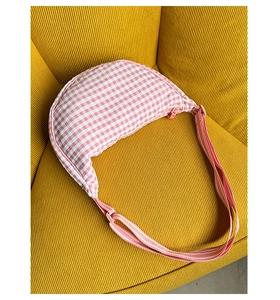 Close-up of pink and white checkered crescent bag with seersucker textured fabric