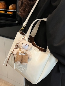 Minimalist beige oil wax leather bucket bag with teddy bear charm and gold hardware