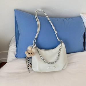 Detail of soft cream white tote bag with adjustable strap and decorative silver chain