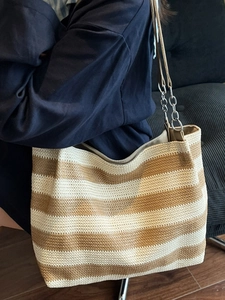 Large woven tote bag with khaki and cream stripes, featuring a metal chain leather strap