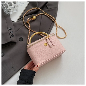 Detailed macro view of pink ostrich pattern bag with golden chain and flower buckle